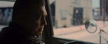 Movie still from “Wrath of Man” (2021), directed by Guy Ritchie – A person sitting in a car looking out the window; Close Up shot, Over the shoulder angle
