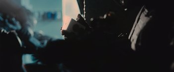 Movie still from “Wrath of Man” (2021), directed by Guy Ritchie – A person holding an object in their hand; Extreme Close Up shot, Over the shoulder angle