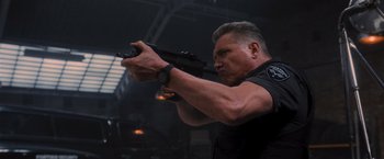 Movie still from “Wrath of Man” (2021), directed by Guy Ritchie – A man in a black shirt is holding a gun; Close Up shot, Low angle