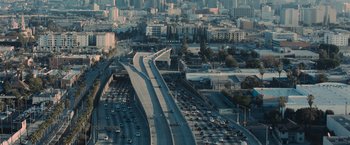 Movie still from “Wrath of Man” (2021), directed by Guy Ritchie – An aerial view of a busy freeway in a metropolitan area; Extreme Wide shot, High angle