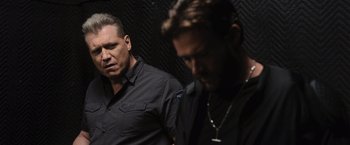 Movie still from “Wrath of Man” (2021), directed by Guy Ritchie – A man in a black shirt and another man in a black shirt; Close Up shot, Over the shoulder angle