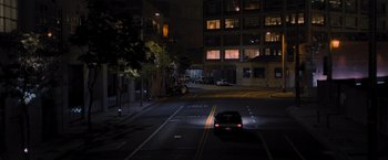 Movie still from “Wrath of Man” (2021), directed by Guy Ritchie – A car driving down a street at night; Extreme Wide shot, High angle