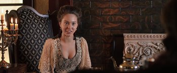 Movie still from “Wuthering Heights” (2022), directed by Bryan Ferriter – A beautiful young lady sitting at a table; Close Up shot, Over the shoulder angle
