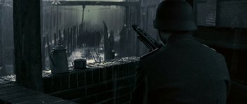 Movie still from “X-Men: First Class” (2011), directed by Matthew Vaughn – A man with a gun in his hand looking out a window; Medium shot, Over the shoulder angle