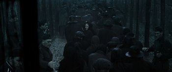 Movie still from “X-Men: First Class” (2011), directed by Matthew Vaughn – A group of people walking through a dark forest; Wide shot, High angle