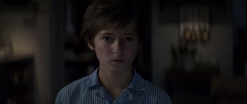 Movie still from “X-Men: First Class” (2011), directed by Matthew Vaughn – A young man in a blue and white striped shirt; Close Up shot, Over the shoulder angle