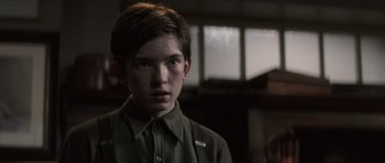 Movie still from “X-Men: First Class” (2011), directed by Matthew Vaughn – A young boy in a green shirt looking at the camera; Close Up shot, Over the shoulder angle