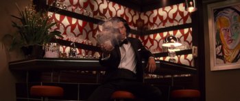 Movie still from “X-Men: First Class” (2011), directed by Matthew Vaughn – A man sitting in a chair in front of a bar; Medium shot, Low angle
