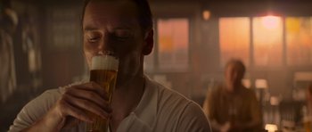 Movie still from “X-Men: First Class” (2011), directed by Matthew Vaughn – A person drinking a beer; Close Up shot, Low angle