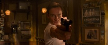 Movie still from “X-Men: First Class” (2011), directed by Matthew Vaughn – A man holding a gun in a room; Close Up shot, Low angle