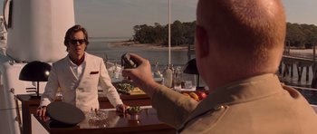 Movie still from “X-Men: First Class” (2011), directed by Matthew Vaughn – A man holding a cell phone in his hand while another man watches; Medium shot, Over the shoulder angle