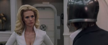 Movie still from “X-Men: First Class” (2011), directed by Matthew Vaughn – A woman in a white dress is looking at a man in a helmet; Close Up shot, Over the shoulder angle