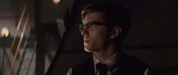 Movie still from “X-Men: First Class” (2011), directed by Matthew Vaughn – A young man wearing glasses and a vest looking to his left; Close Up shot, Over the shoulder angle