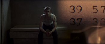 Movie still from “X-Men: First Class” (2011), directed by Matthew Vaughn – A man sitting on a ledge in front of a building; Medium shot, High angle