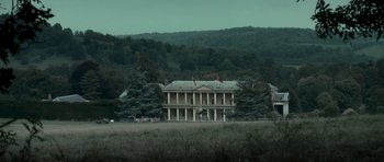 Movie still from “X-Men: First Class” (2011), directed by Matthew Vaughn – A large building in the middle of a field with trees; Extreme Wide shot, Low angle