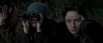 Movie still from “X-Men: First Class” (2011), directed by Matthew Vaughn – Two people are sitting in the dark and one is holding up a camera; Close Up shot, Low angle