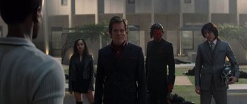 Movie still from “X-Men: First Class” (2011), directed by Matthew Vaughn – A group of people in suits walking down a street; Wide shot, Over the shoulder angle