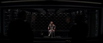 Movie still from “X-Men: First Class” (2011), directed by Matthew Vaughn – A woman sitting on top of a chair in front of a wall; Wide shot, High angle