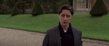 Movie still from “X-Men: First Class” (2011), directed by Matthew Vaughn – A man in a jacket standing in front of some grass; Close Up shot, Over the shoulder angle