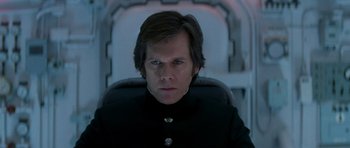 Movie still from “X-Men: First Class” (2011), directed by Matthew Vaughn – A man sitting in a chair wearing a black suit; Close Up shot, Low angle