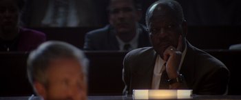 Movie still from “X-Men” (2000), directed by Bryan Singer – A man sitting at a table in front of another man in a suit; Close Up shot, Over the shoulder angle