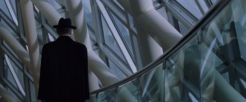 Movie still from “X-Men” (2000), directed by Bryan Singer – A man standing on a balcony next to a glass railing; Medium shot, Low angle