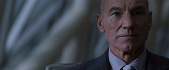 Movie still from “X-Men” (2000), directed by Bryan Singer – A man in a suit and tie looking to his left; Close Up shot, Over the shoulder angle