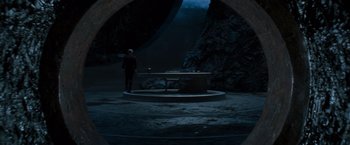 Movie still from “X-Men” (2000), directed by Bryan Singer – A man standing in front of a table in the dark; Wide shot, High angle