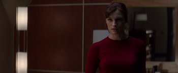 Movie still from “X-Men” (2000), directed by Bryan Singer – A woman in a red shirt standing in front of a wall; Medium shot, Over the shoulder angle