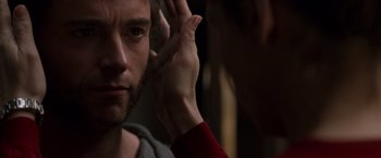 Movie still from “X-Men” (2000), directed by Bryan Singer – A man's face with his hand up to his ear; Close Up shot, Over the shoulder angle