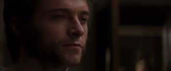 Movie still from “X-Men” (2000), directed by Bryan Singer – A man's face in a dark room; Close Up shot, Over the shoulder angle