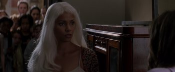 Movie still from “X-Men” (2000), directed by Bryan Singer – A woman with white hair is standing in front of a cabinet; Close Up shot, Over the shoulder angle