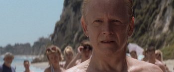 Movie still from “X-Men” (2000), directed by Bryan Singer – A group of people standing on top of a sandy beach; Close Up shot, Low angle