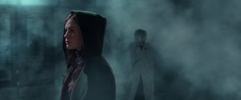 Movie still from “X-Men” (2000), directed by Bryan Singer – A woman standing in front of a man in a white coat; Medium shot, Over the shoulder angle