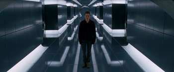 Movie still from “X-Men” (2000), directed by Bryan Singer – A man standing in a room with lights on the walls; Wide shot, Low angle
