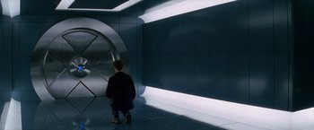Movie still from “X-Men” (2000), directed by Bryan Singer – A man is standing in front of a wall; Wide shot, High angle