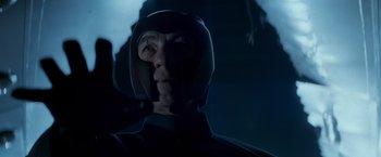 Movie still from “X-Men” (2000), directed by Bryan Singer – A man in a black suit and a black helmet; Close Up shot, Low angle