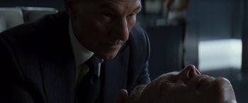 Movie still from “X-Men” (2000), directed by Bryan Singer – An older man wearing a suit and tie looking at a woman; Close Up shot, Over the shoulder angle