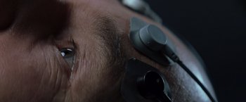 Movie still from “X-Men” (2000), directed by Bryan Singer – A man's face with ear buds attached; Extreme Close Up shot, Overhead angle