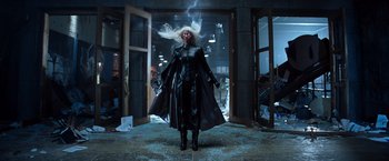 Movie still from “X-Men” (2000), directed by Bryan Singer – A woman in a black outfit standing in a room; Wide shot, Low angle
