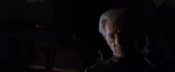 Movie still from “X-Men” (2000), directed by Bryan Singer – An older man in a black shirt is looking at the camera; Close Up shot, Low angle