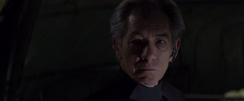 Movie still from “X-Men” (2000), directed by Bryan Singer – An older man in a black shirt looking at the camera; Close Up shot, Low angle