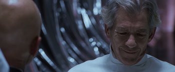 Movie still from “X-Men” (2000), directed by Bryan Singer – An older man in a white shirt is looking down; Close Up shot, Over the shoulder angle