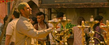 Movie still from “X-Men: Apocalypse” (2016), directed by Bryan Singer – A woman with a shaved head is standing in front of a hookah stand; Medium shot, Over the shoulder angle