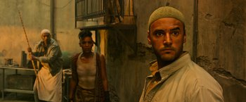 Movie still from “X-Men: Apocalypse” (2016), directed by Bryan Singer – A man and a woman standing next to each other in front of a building; Close Up shot, Low angle