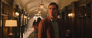 Movie still from “X-Men: Apocalypse” (2016), directed by Bryan Singer – A man wearing glasses and a brown jacket standing in a hallway; Medium shot, Low angle