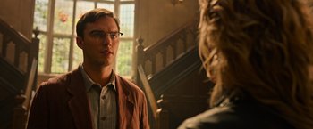 Movie still from “X-Men: Apocalypse” (2016), directed by Bryan Singer – A man wearing glasses talking to a woman in front of a staircase; Close Up shot, Over the shoulder angle