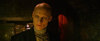 Movie still from “X-Men: Apocalypse” (2016), directed by Bryan Singer – A man with bald head and green eyes looking at the camera; Close Up shot, Low angle