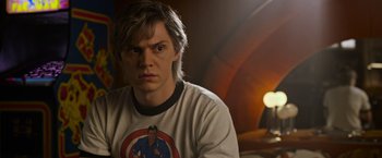 Movie still from “X-Men: Apocalypse” (2016), directed by Bryan Singer – A young man with blonde hair and a captain america t - shirt; Close Up shot, Over the shoulder angle