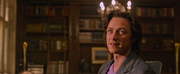 Movie still from “X-Men: Apocalypse” (2016), directed by Bryan Singer – A person in a room with a book shelf in the background; Close Up shot, Over the shoulder angle